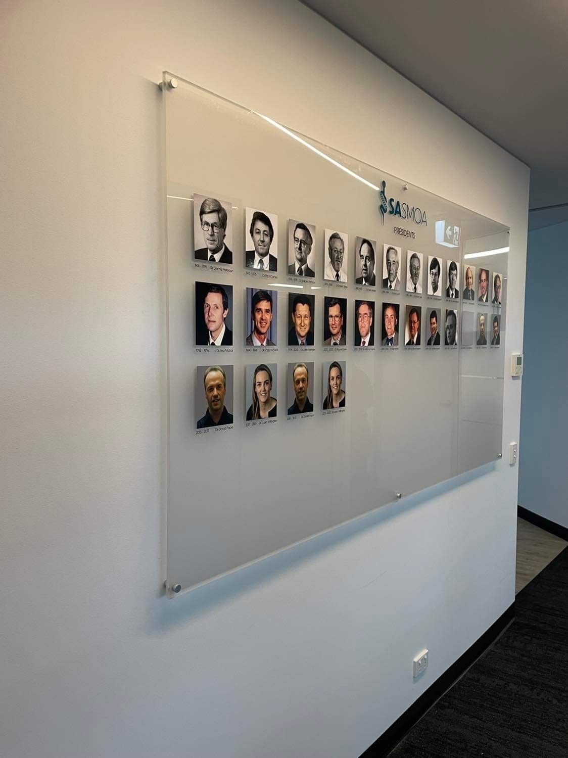 A glass board with pictures of people on it
