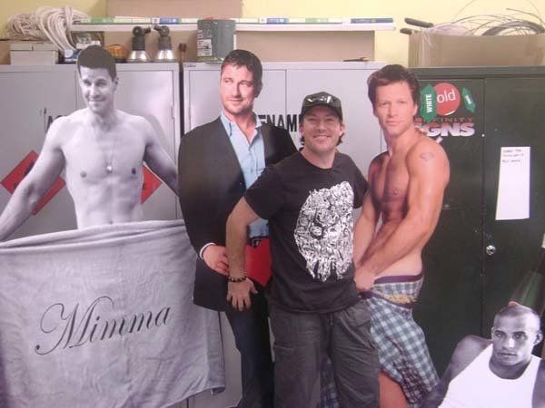 man standing next to person cutout signs